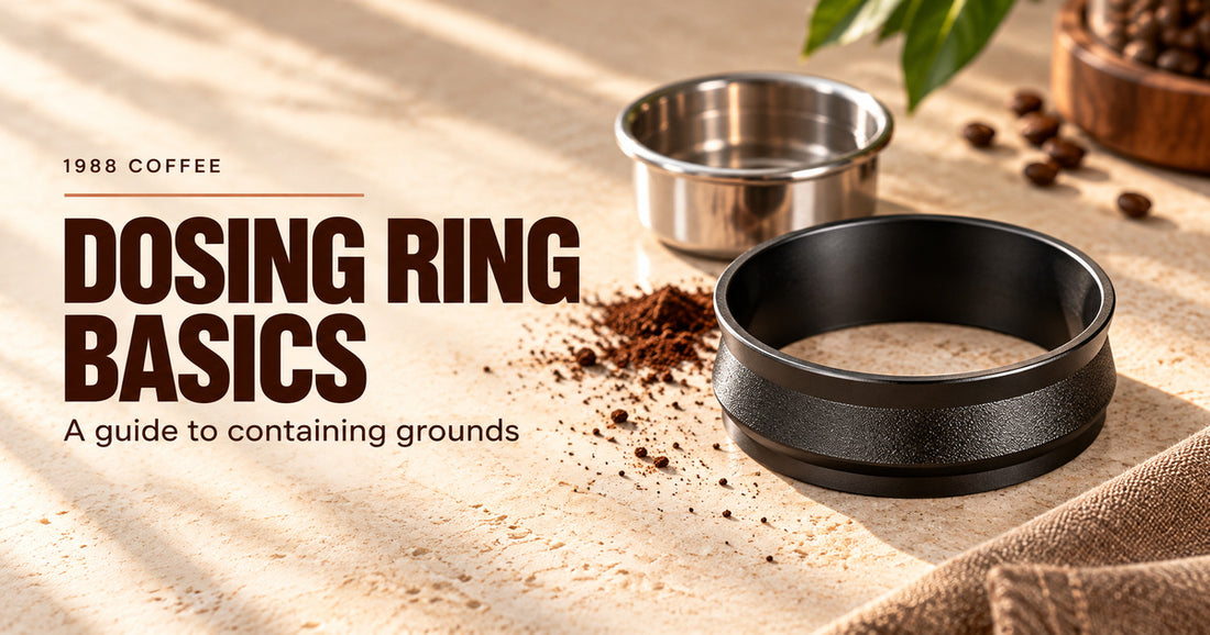Editorial illustration of a hollow black dosing ring, a separate empty metal basket and a few coffee grounds on a pale counter.