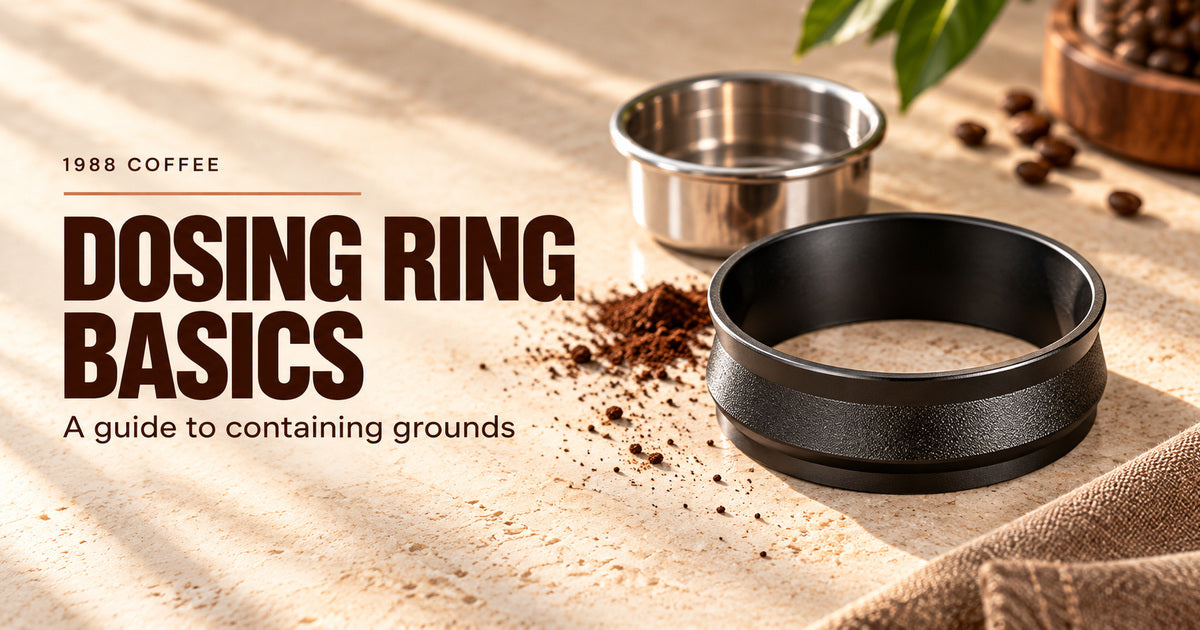 Editorial illustration of a hollow black dosing ring, a separate empty metal basket and a few coffee grounds on a pale counter.